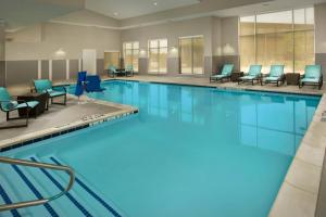 a large swimming pool with blue chairs and tables at Residence Inn by Marriott Tyler in Tyler