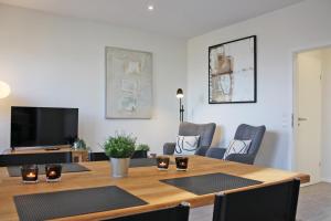 a dining room with a table and a tv at fewo1846 - Ankerplatz I in Flensburg