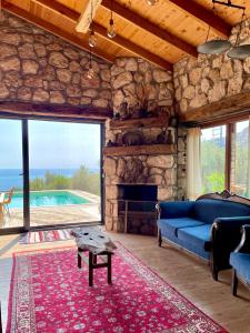 a living room with a blue couch and a stone fireplace at Shavilla Kalkan - Yalı ' da Korunaklı 1+1 Villa in Patara