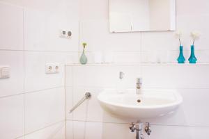 a white bathroom with a sink and a mirror at fewo1846 - Ankerplatz I in Flensburg