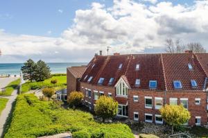 an aerial view of a brick building with the ocean in the background at Godewind Ausguck C3 in Kronsgaard