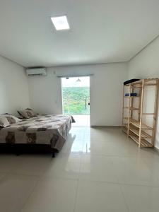 ein Schlafzimmer mit einem Bett und einem großen Fenster in der Unterkunft Estadia Wolf Lencois in Lençóis