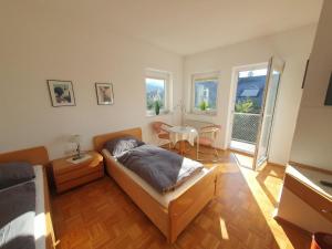 1 dormitorio con cama, mesa y ventanas en ABM Apartment 26, en Zwingenberg