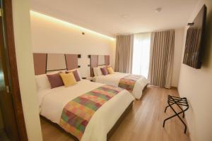 La EsperanzaElithe Hotel的有两张床和一扇窗户的酒店房间