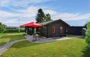 una piccola cabina con un ombrello rosso in un cortile di Two-Bedroom Holiday Home In Nordborg a Nordborg
