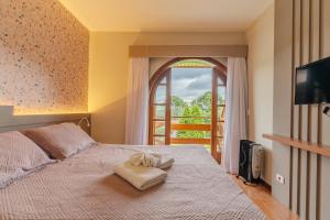 een slaapkamer met een groot bed en een raam bij @MineirINN l Piscina Aquecida e Hidro na Serra in Campos do Jordão