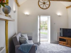 a living room with a couch and a tv at River View Cottage in Knaresborough