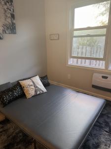 a couch in a room with a window at Charlotte tiny Home getaway 5 min to lake Wylie in Charlotte