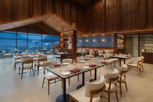 索纳马格Four Points by Sheraton Sonmarg Resort的有桌椅和窗户的餐厅