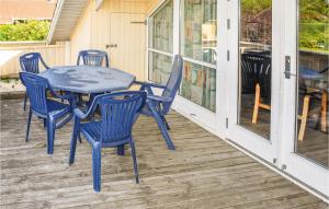ノーポにあるBeautiful Home In Nordborg With 3 Bedrooms, Sauna And Wifiの青いテーブルと椅子が置かれたポーチ