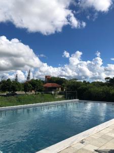 a large pool of blue water with a sky at Bangalô Doce lar in Gravatá