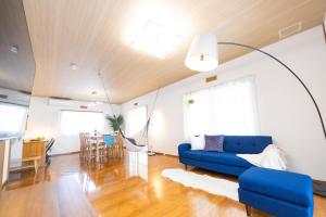 a living room with a blue couch and a table at Shiga Lakeside House in Hamabun in Imazu