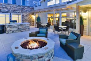 a patio with a fire pit and chairs and tables at Residence Inn by Marriott Champaign in Champaign