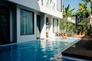 two people in the swimming pool of a house at POR Arak in Chiang Mai