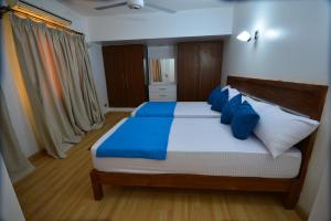 une chambre avec un grand lit avec des oreillers bleus dans l'établissement Sea Front Apartment, à Charm el-Cheikh