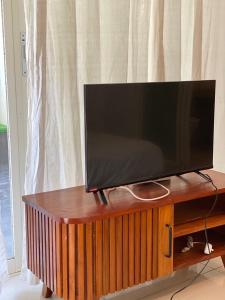 努沙杜瓦3 BR Chrysanthemum Villa nusadua的木架上配有平面电视