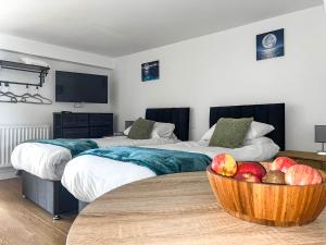 two beds in a room with a bowl of fruit on a table at Honeymead - Uk46952 in Blackwood