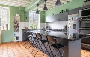 una cucina con un grande bancone con sedie di Magnifique Maison Avec Piscine a Villotran