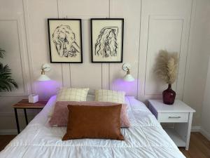 Modern Stay near Disney & LA في بيلفلاوير: غرفة نوم بها ثلاث رسومات اطارية على الحائط