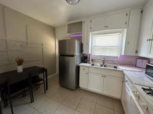 a kitchen with a stainless steel refrigerator and a table at Modern Stay near Disney & LA in Bellflower