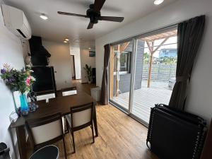 a living room with a dining table and a sliding glass door at サザンメモリ今帰仁 in Nakijin