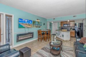 ein Wohnzimmer mit einem Sofa, einem Tisch und einer Küche in der Unterkunft Luxurious Ocean view Queen Suite - With New LED Fireplace! Palace Resort Unit 2210 in Myrtle Beach