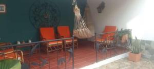 uma sala de estar com cadeiras laranja e uma rede de descanso em Casa Hotel Villa Lunita em Villa de Leyva