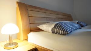 uma cama com uma almofada e um candeeiro sobre uma mesa em Ferienwohnung Am Feldbach em Bad Aibling