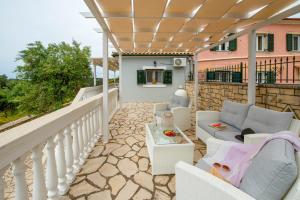 a patio with chairs and a table on a balcony at Militsa House in Gaios