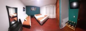 um pequeno quarto com uma cama e um espelho em Casa Hotel Villa Lunita em Villa de Leyva