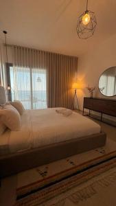a bedroom with a large white bed and a window at شقة فاخرة بإطلالة بحرية كاملة in Jeddah