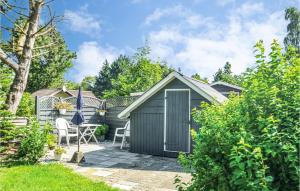 um barracão com uma mesa e cadeiras num jardim em Nice Home In Vggerlse With Wifi em Bøtø By