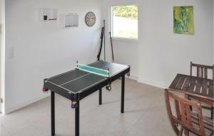 a ping pong table in a room with a chair at Amazing Home In Augustenborg With 4 Bedrooms, Sauna And Wifi in Asserballeskov