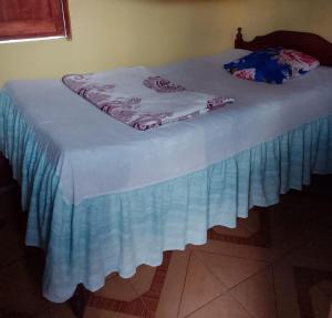 a bed with a blue bed skirt on it at Casa Ricardo Sonis in Somoto