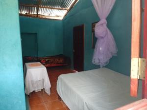 um quarto azul com duas camas e uma mesa em Casa Ricardo Sonis em Somoto