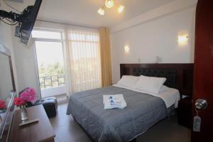 a hotel room with a bed and a window at Mar Azul in Paracas