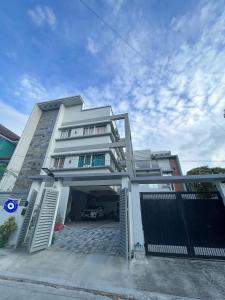 un grand bâtiment blanc avec un garage dans l'établissement The Cozy Casita, à Manille