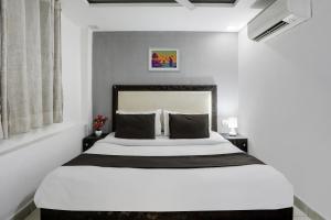 um quarto com uma grande cama branca com duas mesas de cabeceira em Super OYO Hotel Mannat Near Lotus Temple em Nova Deli