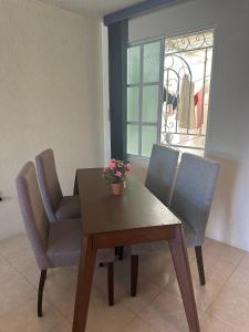 ein Esszimmer mit einem Tisch, Stühlen und einem Fenster in der Unterkunft Casa Vazquez Colinas Plata in Cadena