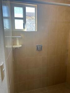 ein Bad mit einer Dusche und einem Fenster in der Unterkunft Casa Vazquez Colinas Plata in Cadena