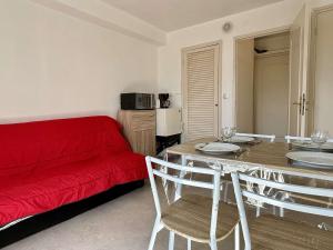 uma sala de estar com um sofá vermelho e uma mesa em Appartement Argelès-sur-Mer, 2 pièces, 4 personnes - FR-1-225-814 em Argelès-sur-Mer
