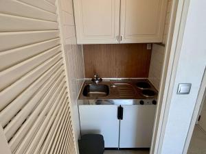 uma pequena cozinha com armários brancos e um lavatório em Appartement Argelès-sur-Mer, 2 pièces, 4 personnes - FR-1-225-814 em Argelès-sur-Mer