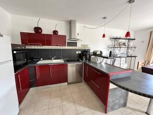una cucina con armadi rossi e frigorifero bianco di Maison L'Isle-sur-la-Sorgue, 3 pièces, 4 personnes - FR-1-767-20 a LʼIsle-sur-la-Sorgue