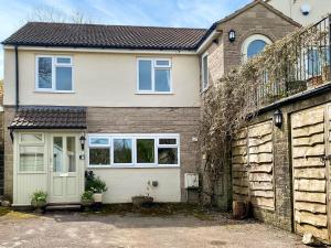 ein Haus mit einer Garage und einem Zaun in der Unterkunft Anjou Bijou in Westbury-sub-Mendip