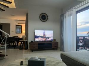 un salon avec une télévision à écran plat sur un mur dans l'établissement Sea View Villa @ Nongsa Resort, à Telukmataikan