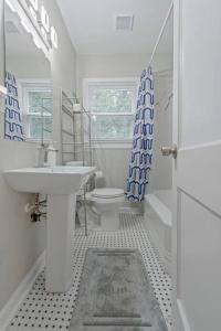 La salle de bains blanche est pourvue d'un lavabo et de toilettes. dans l'établissement GoodLiving: Decatur's Gem, à Decatur