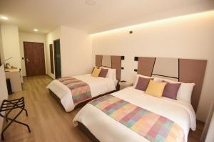 La EsperanzaElithe Hotel的一间酒店客房,房间内设有两张床 更多10张照片