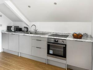 a kitchen with white cabinets and a stove top oven at Highmead - Uk46951 in Blackwood