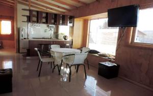 a living room with a table and chairs and a television at Cabañas el mirador de Rio Claro in Río Claro