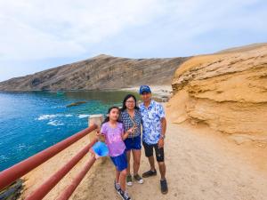 a man and a woman standing next to the ocean at Mar Azul in Paracas